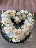 Cœur ouvert de roses blanches et œillets – fleurs de deuil